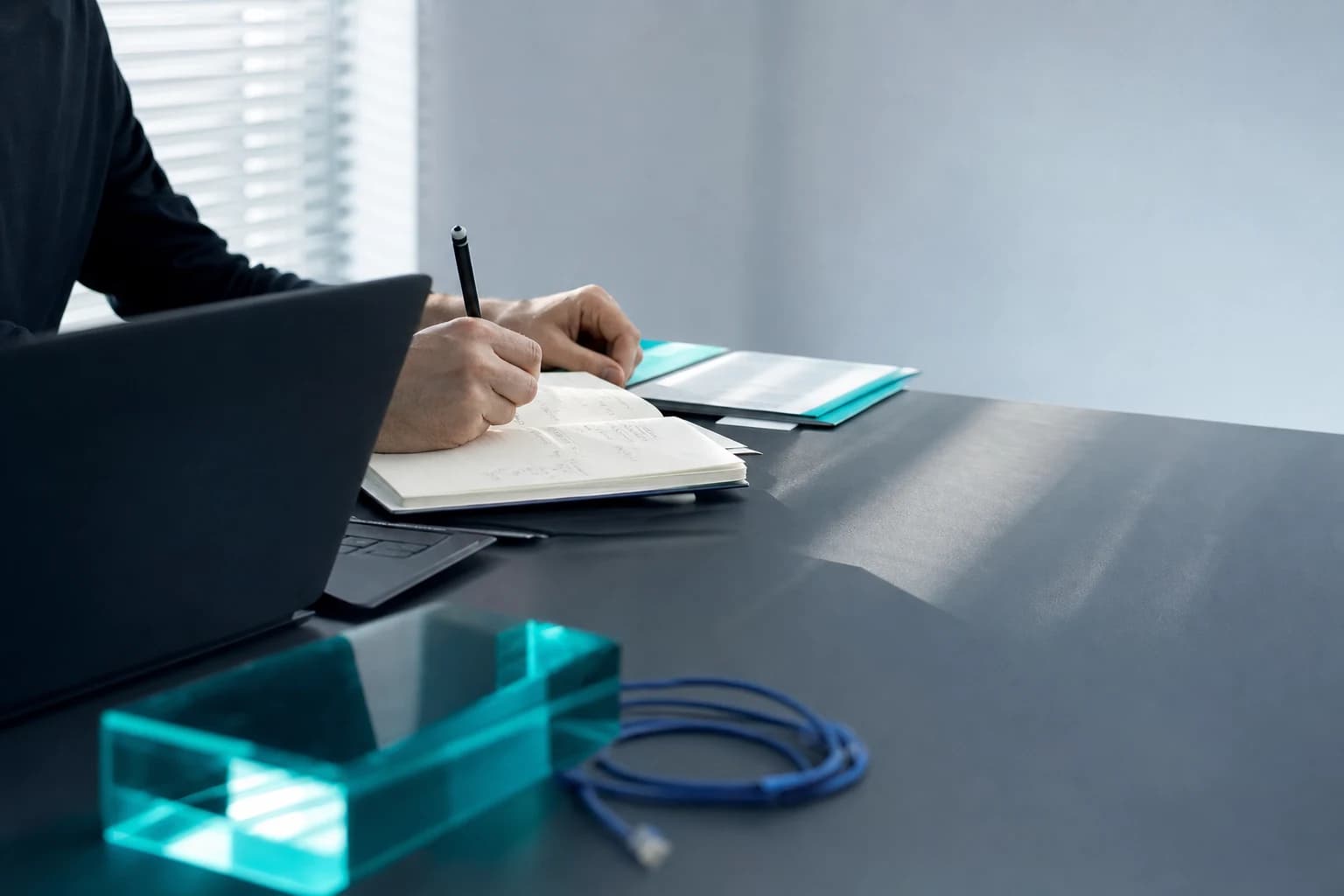 A developer's notebook and laptop in cool daylight